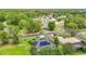 Aerial view showcases a community with tree-lined streets, well-manicured lawns, and solar panels at 30 Lake Diamond Ave, Ocala, FL 34472