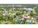 Aerial view of the community with tree-lined streets and lake featuring well-maintained landscaping and homes with solar panels at 30 Lake Diamond Ave, Ocala, FL 34472
