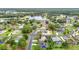 Aerial view of neighborhood with lake featuring tree-lined streets and well-maintained homes with swimming pools at 30 Lake Diamond Ave, Ocala, FL 34472