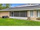 View of screened-in lanai, backyard, and solar panels on the roof of the home at 30 Lake Diamond Ave, Ocala, FL 34472