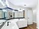 Bathroom featuring white countertop, double sinks and cabinets with updated fixtures and modern mirror at 30 Lake Diamond Ave, Ocala, FL 34472