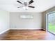 A neutrally decorated bedroom featuring hardwood floors, ceiling fan, and backyard view at 30 Lake Diamond Ave, Ocala, FL 34472