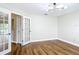 Bright bedroom featuring hardwood floors, french doors, and a modern light fixture at 30 Lake Diamond Ave, Ocala, FL 34472