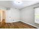 Bright bedroom featuring beautiful wood flooring, a window with blinds, and a white door at 30 Lake Diamond Ave, Ocala, FL 34472