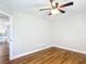 Bedroom with wood flooring, ceiling fan, view into hallway, and neutral color palette at 30 Lake Diamond Ave, Ocala, FL 34472