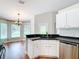 Eat-in kitchen offers stainless appliances, white cabinets, and black counters, adjacent to a dining area with bright windows at 30 Lake Diamond Ave, Ocala, FL 34472