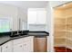 Kitchen with black counters, stainless steel appliances, pantry, and white cabinets offers a functional and stylish space at 30 Lake Diamond Ave, Ocala, FL 34472