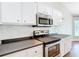White cabinets, subway tile backsplash, and stainless steel appliances outfit this modern and functional kitchen at 30 Lake Diamond Ave, Ocala, FL 34472