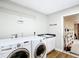 Laundry room features updated washer and dryer set, sink, storage, and access to the garage at 30 Lake Diamond Ave, Ocala, FL 34472