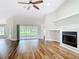 Bright living room featuring hardwood floors, a fireplace, and sliding glass doors leading to the outside at 30 Lake Diamond Ave, Ocala, FL 34472