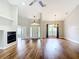 Spacious living room with hardwood floors, a fireplace, a ceiling fan, and large windows providing natural light at 30 Lake Diamond Ave, Ocala, FL 34472