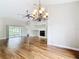 Bright living room features a decorative fireplace and an ornate chandelier, complemented by wood-look floors at 30 Lake Diamond Ave, Ocala, FL 34472