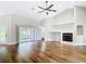 Bright living room with hardwood floors, a fireplace, and sliding glass doors leading to a spacious patio at 30 Lake Diamond Ave, Ocala, FL 34472