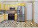 Modern kitchen with stainless steel appliances and beautiful yellow cabinets at 3811 Gator Bay Ln, St Cloud, FL 34772