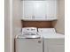 Functional laundry room with modern washer, dryer, and overhead cabinets at 3811 Gator Bay Ln, St Cloud, FL 34772