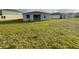 A spacious backyard features a lush lawn and a covered patio, ideal for outdoor relaxation and entertainment at 4053 Redbridge Loop, Davenport, FL 33837