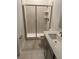Modern bathroom with tile shower, glass door, neutral tile, quartz countertop, gray cabinets and fixtures at 4053 Redbridge Loop, Davenport, FL 33837