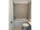 Bathroom featuring a tiled shower-tub, tile floor, toilet and gray vanity at 4053 Redbridge Loop, Davenport, FL 33837