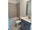 Bathroom displaying a tub-shower, toilet and gray vanity with faucet at 4053 Redbridge Loop, Davenport, FL 33837