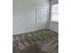 Bedroom featuring a window, neutral carpet, and closet with bi-fold doors at 4053 Redbridge Loop, Davenport, FL 33837