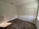 Bedroom featuring a window, neutral carpet, and closet with bi-fold doors at 4053 Redbridge Loop, Davenport, FL 33837