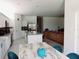 Open-concept kitchen with white cabinets, granite countertops, stainless steel appliances, and seamless flow to dining area at 409 Conway Ave, St Cloud, FL 34771