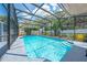 Sparkling pool enclosed within a screen, surrounded by lush landscaping and a beautiful sky view at 435 Pennsylvania Ave, St Cloud, FL 34769