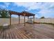 Spacious backyard with a wooden deck and pergola, perfect for outdoor entertaining at 454 Hamlet Loop, Davenport, FL 33837