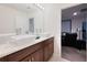 Bathroom featuring double vessel sinks, modern fixtures, and a view into a bonus room at 454 Hamlet Loop, Davenport, FL 33837