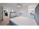 Spacious bedroom with gray dresser and mirror, ceiling fan, with open doorway to a sitting room at 454 Hamlet Loop, Davenport, FL 33837
