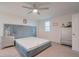 Light-filled bedroom featuring gray upholstered bed frame, ceiling fan, and neutral carpeting at 454 Hamlet Loop, Davenport, FL 33837