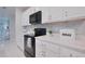 Modern kitchen with stainless steel appliances, quartz countertops, and white cabinetry for a clean look at 454 Hamlet Loop, Davenport, FL 33837