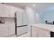 Modern kitchen featuring stainless steel appliances and white quartz countertops, with access to dining area at 454 Hamlet Loop, Davenport, FL 33837