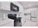 Well-lit kitchen with stainless steel appliances, quartz countertops, and sleek cabinetry, offering modern convenience at 454 Hamlet Loop, Davenport, FL 33837