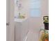 Practical laundry room with a washer, dryer, storage shelf, and natural light from the window at 454 Hamlet Loop, Davenport, FL 33837