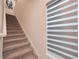 Carpeted staircase with a window and stylish blinds leading to the upper level at 454 Hamlet Loop, Davenport, FL 33837