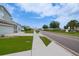 Neighborhood street with sidewalks, manicured lawns, palm trees, and visible homes at 454 Hamlet Loop, Davenport, FL 33837