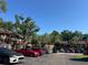Community parking area with lush landscaping, townhomes, and blue skies at 4905 Sanoma Vlg # Ge, Orlando, FL 32808
