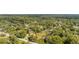 Expansive aerial view of a residential neighborhood filled with mature trees and lush greenery at 525 W Blue Springs Ave, Orange City, FL 32763
