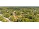 A high angle, slightly distant aerial view showcases a residence nestled among trees in a lush neighborhood at 525 W Blue Springs Ave, Orange City, FL 32763