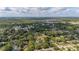 Aerial view of a residence nestled among trees in a lush neighborhood; a radio tower is visible in the distance at 525 W Blue Springs Ave, Orange City, FL 32763