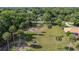 Backyard with palm trees and a large grassy field leading up to the main home at 525 W Blue Springs Ave, Orange City, FL 32763