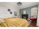 Cozy bedroom with a black fireplace, ceiling fan, and comfortable furnishings at 525 W Blue Springs Ave, Orange City, FL 32763