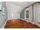 Bright bedroom with hardwood floors, textured accent wall, and neutral curtains, creating a cozy and inviting space at 525 W Blue Springs Ave, Orange City, FL 32763