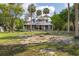 Attractive two-story home featuring a wrap-around porch, mature trees, and a charming front fountain at 525 W Blue Springs Ave, Orange City, FL 32763