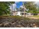Scenic exterior showcasing a two-story home with a screened porch and lush greenery at 525 W Blue Springs Ave, Orange City, FL 32763