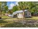 Quaint cottage featuring a well-maintained lawn and an adjacent car at 525 W Blue Springs Ave, Orange City, FL 32763