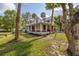 Inviting two-story home featuring a charming wrap-around porch and lush landscaping at 525 W Blue Springs Ave, Orange City, FL 32763