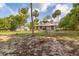 Classic two-story home featuring a charming front porch, mature trees, and landscaped yard at 525 W Blue Springs Ave, Orange City, FL 32763