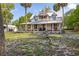Beautifully landscaped two-story home featuring a charming front porch and mature trees at 525 W Blue Springs Ave, Orange City, FL 32763